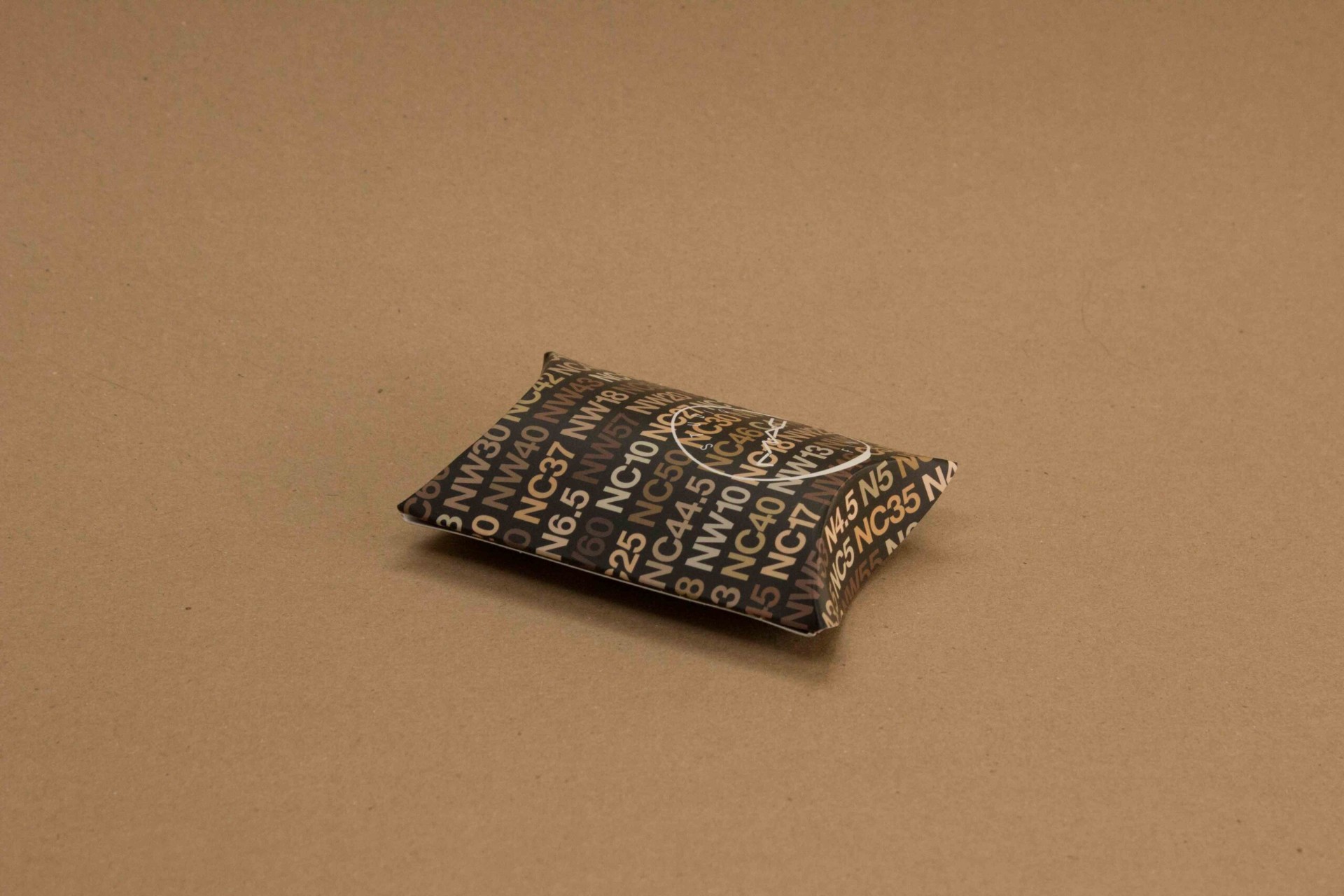 MAC Cosmetics foundation shade pillow pack with gold foil shade codes on black MAC Cosmetics foundation shade pillow pack with gold foil shade codes on black